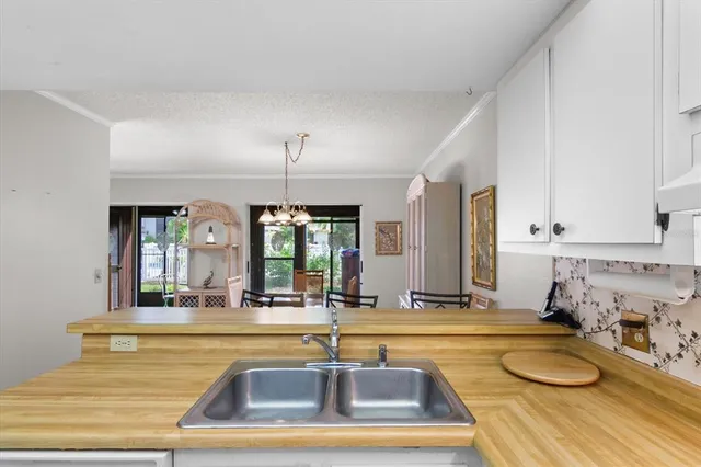 a view of a kitchen with kitchen island a sink and a chandelier