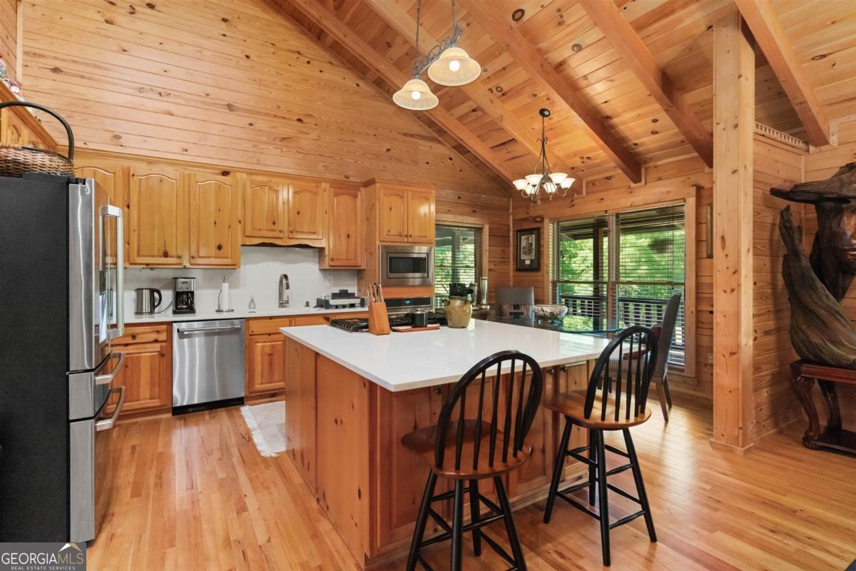224 Harmony Road Eatonton, GA 31024 - Photo 15 of 68 a kitchen with a table chairs refrigerator and cabinets