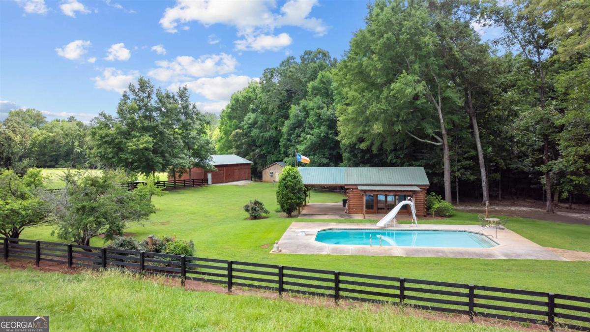 224 Harmony Road Eatonton, GA 31024 - Photo 44 of 68 a view of a swimming pool with lounge chairs in the patio
