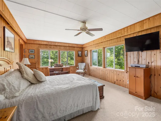 a bedroom with a large bed and a flat tv screen