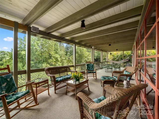 a living room with patio furniture and a floor to ceiling window