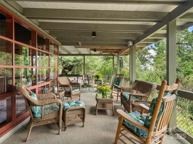 a view of a patio with chairs and floor to ceiling window
