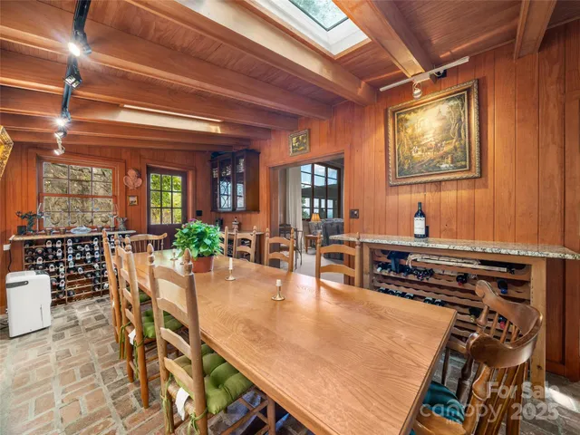 a dining hall with stainless steel appliances granite countertop a stove a refrigerator a dining table and chairs with wooden floor