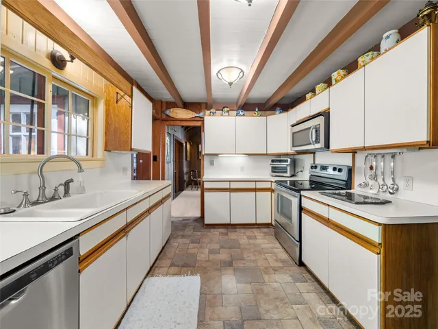 a kitchen with stainless steel appliances granite countertop a sink and cabinets