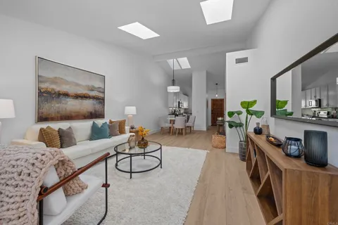 a living room with furniture a flat screen tv and a potted plant