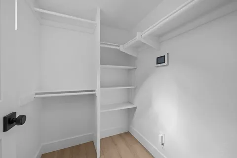 a view of walk in closet with empty racks