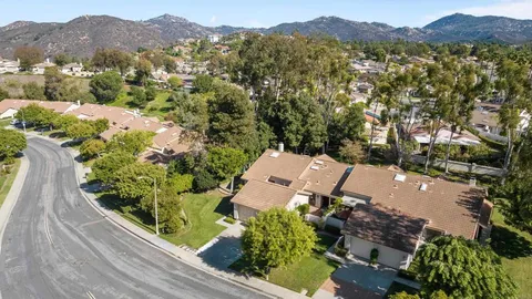 an aerial view of a house with a mountain