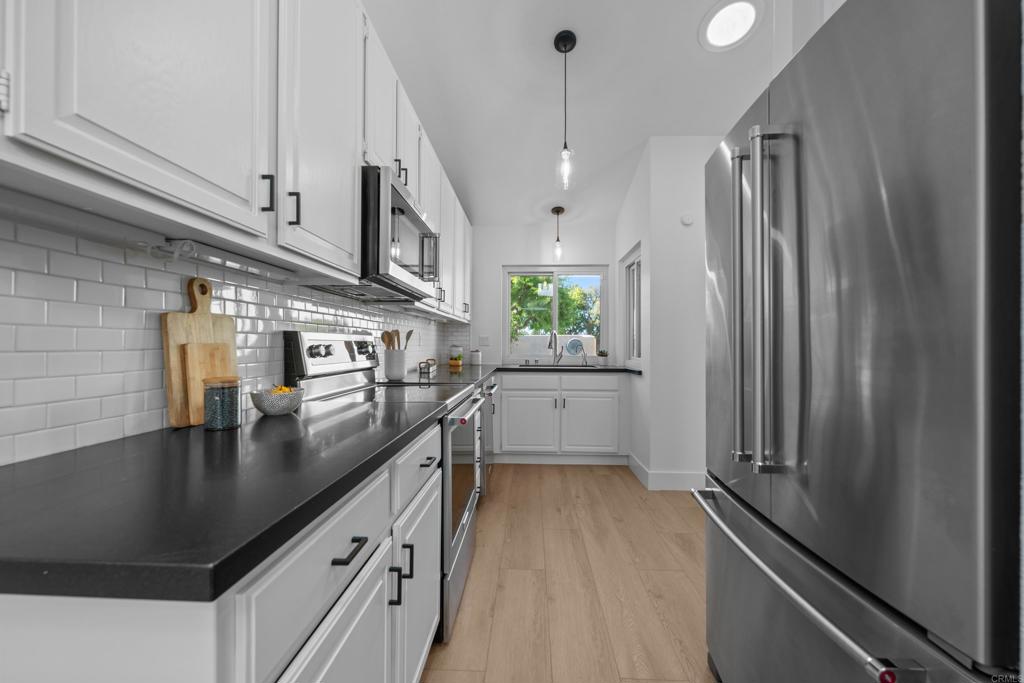 17823 Avenida Alozdra San Diego, CA 92128 - Photo 10 of 28 a kitchen with stainless steel appliances granite countertop a sink a stove and a refrigerator