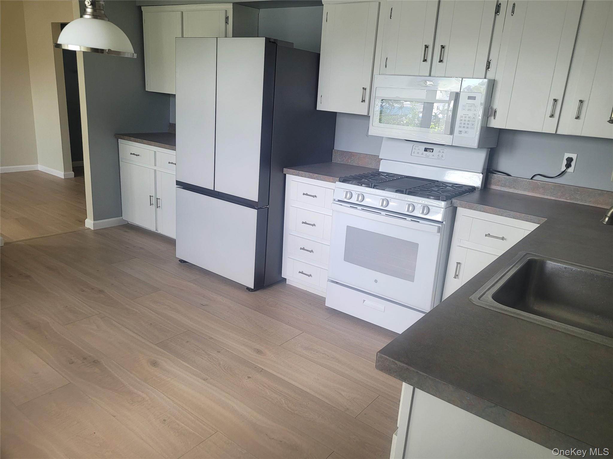 8 Cornell Road East Patchogue, NY 11772 - Photo 7 of 18 a kitchen with stainless steel appliances white cabinets and a refrigerator