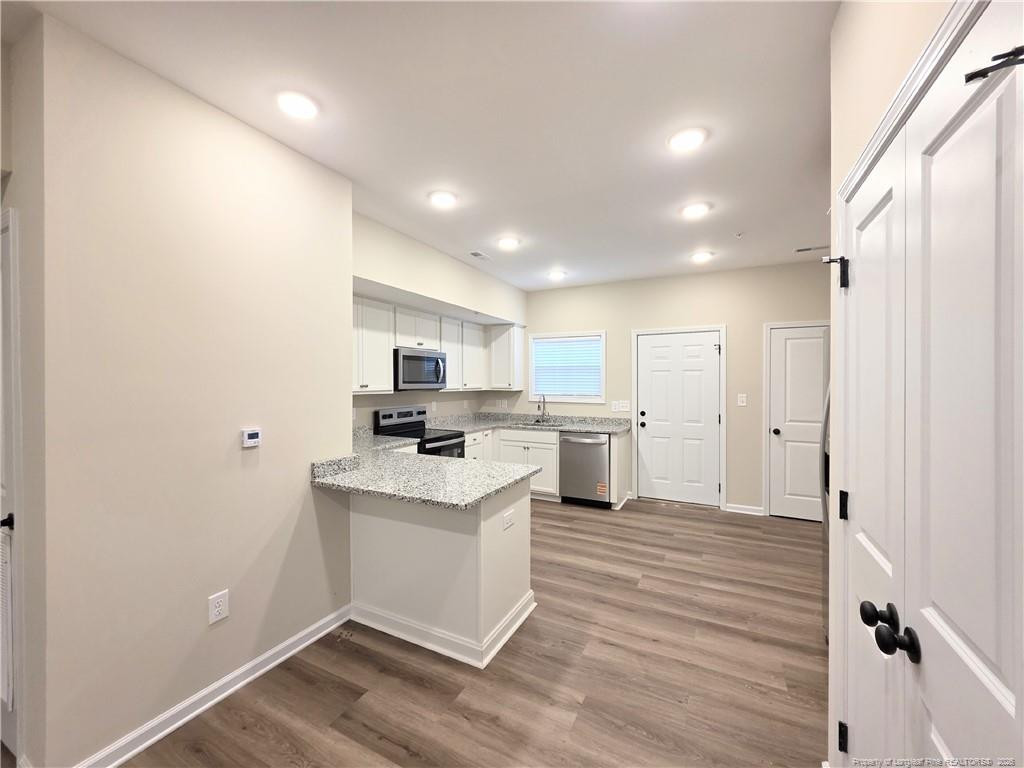 1511 Fort Bragg Road, Unit E Fayetteville, NC 28305 - Photo 5 of 15 a kitchen with white cabinets and white appliances