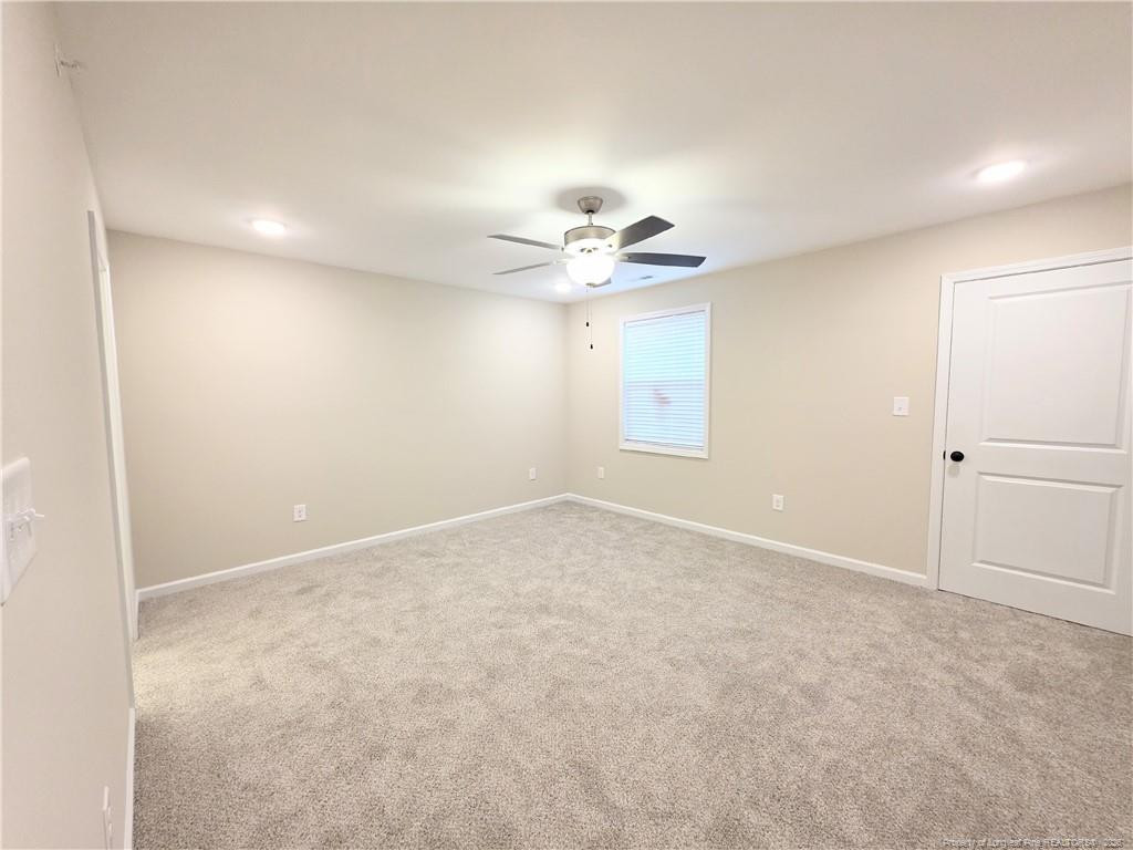 1511 Fort Bragg Road, Unit E Fayetteville, NC 28305 - Photo 7 of 15 an empty room with a chandelier fan and windows