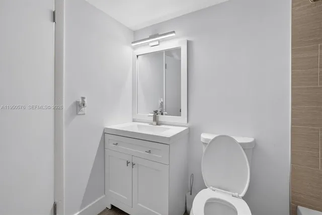 a bathroom with a toilet a sink and mirror