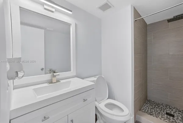 a bathroom with a sink a toilet and shower