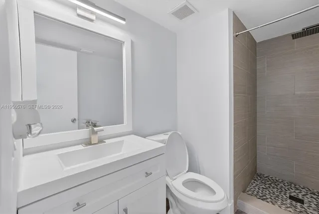 a bathroom with a sink a toilet and shower