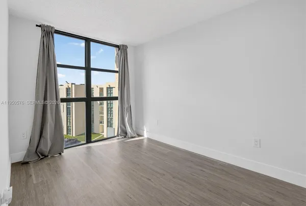 an empty room with wooden floor and a window