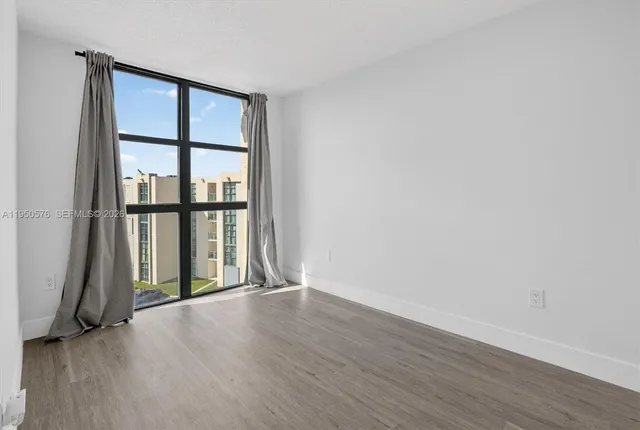 an empty room with wooden floor and a window