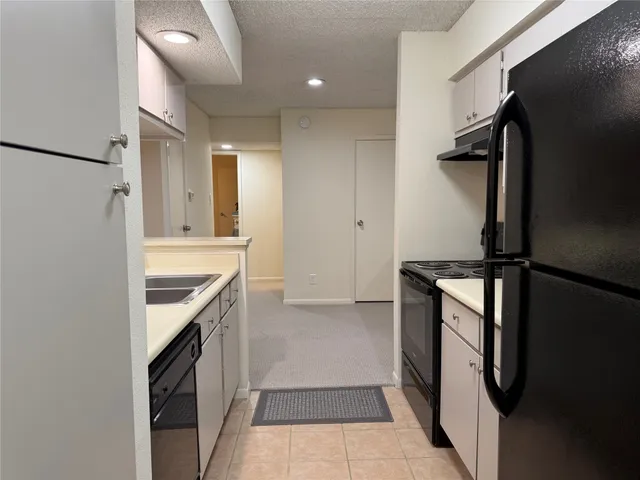 a kitchen with granite countertop a refrigerator and a sink
