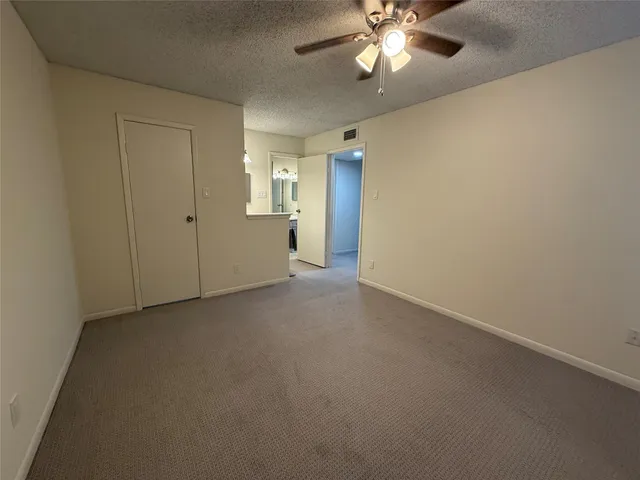 an empty room with a ceiling fan and a window
