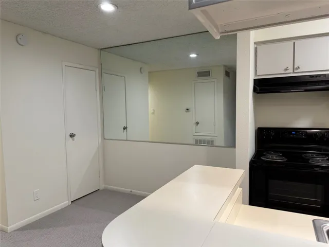 a kitchen with granite countertop white cabinets and black appliances
