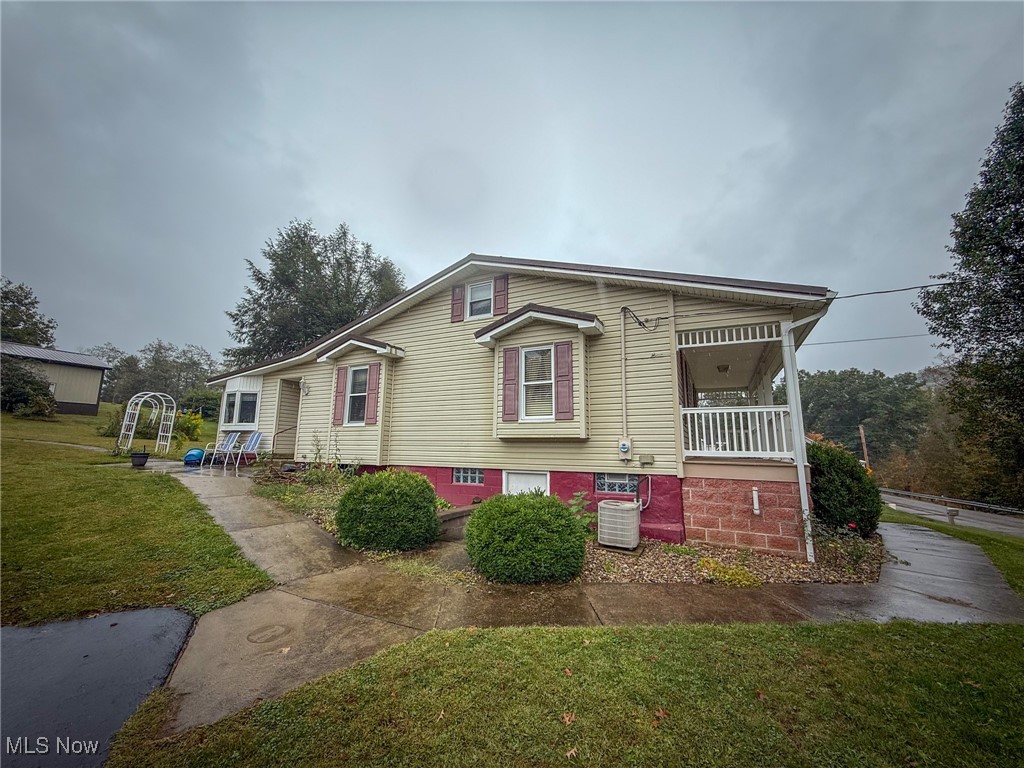 View of front facade with a front lawn and covered porch
