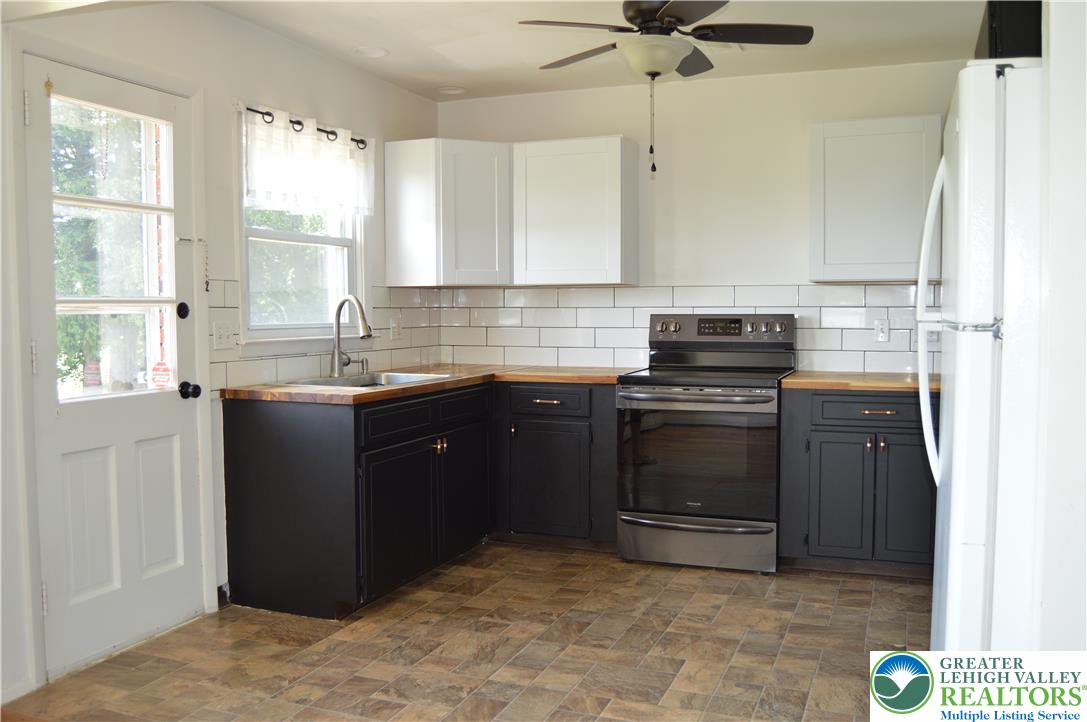 1819 Blue Barn Road Orefield, PA 18069 - Photo 12 of 21 A corner kitchen layout offers ample space with dark cabinetry and natural wood countertops.