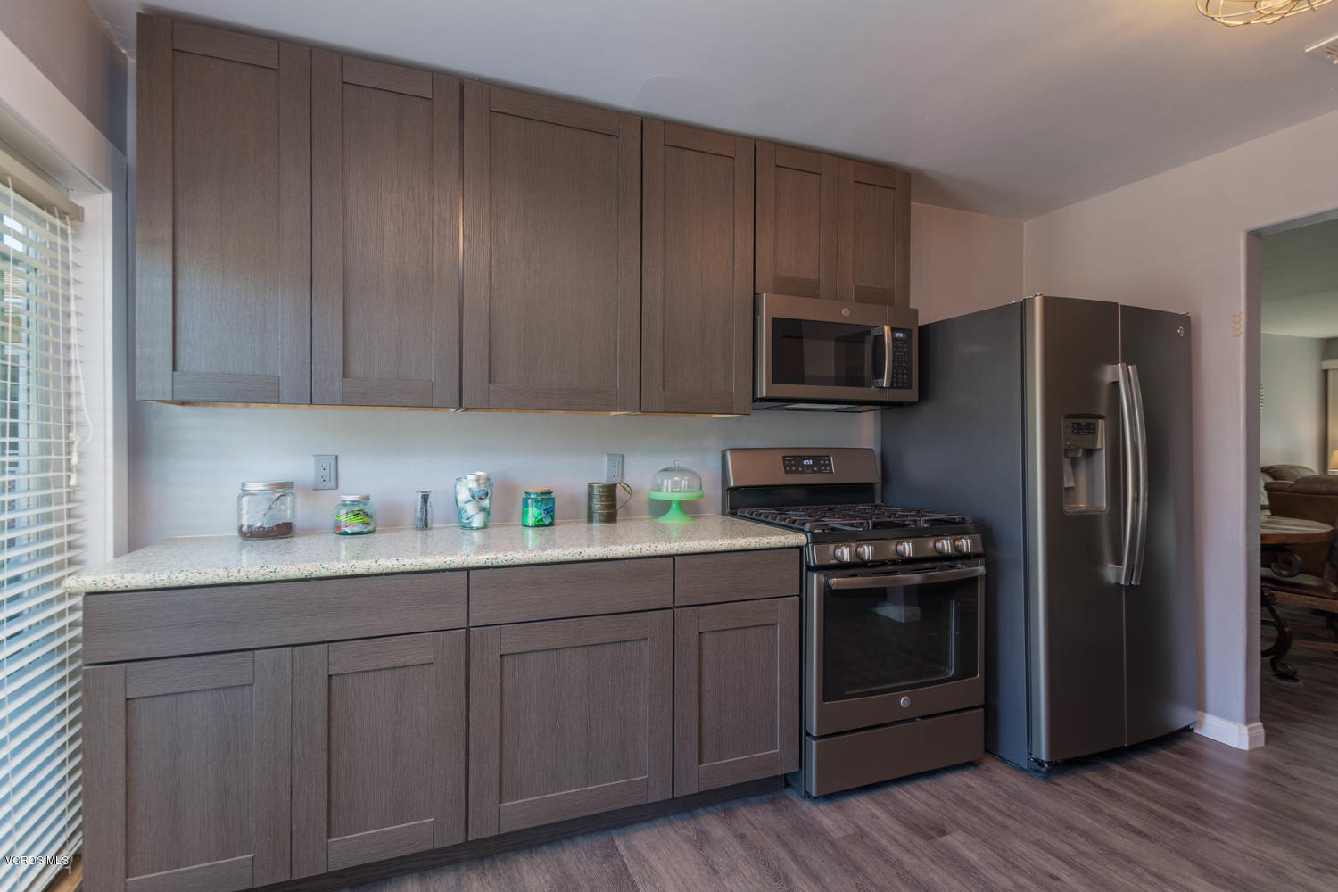 919 Laurel Road Santa Paula, CA 93060 - Photo 2 of 21 a kitchen with stainless steel appliances granite countertop a refrigerator stove a sink and dishwasher with wooden floor
