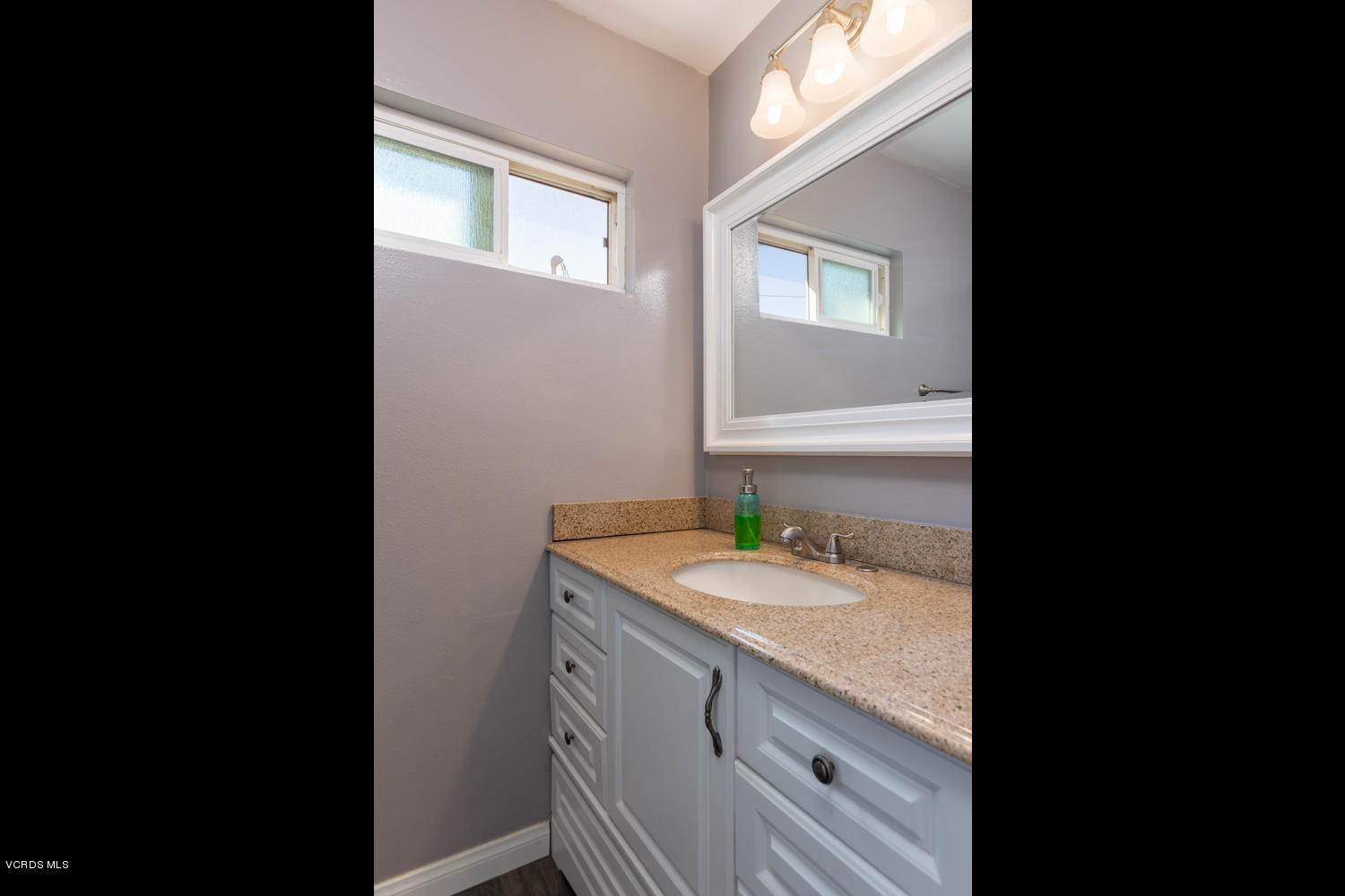 919 Laurel Road Santa Paula, CA 93060 - Photo 18 of 21 a bathroom with a granite countertop sink mirror and vanity