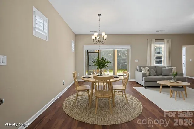a dining room with furniture a chandelier and wooden floor
