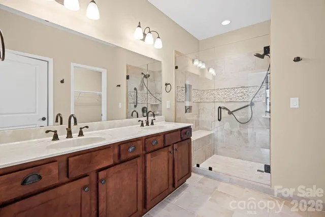 a bathroom with a double vanity sink mirror double and shower