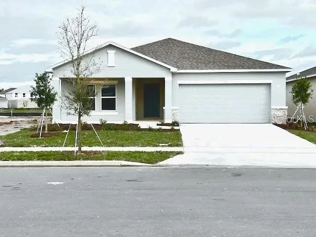 a view of a white house with a yard and plants