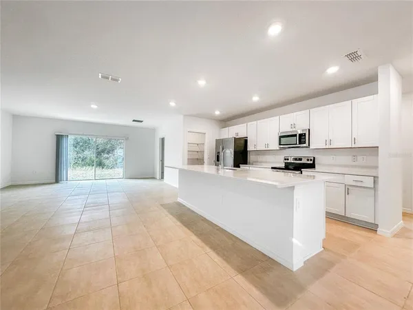 a kitchen with stainless steel appliances granite countertop a refrigerator sink stove and oven