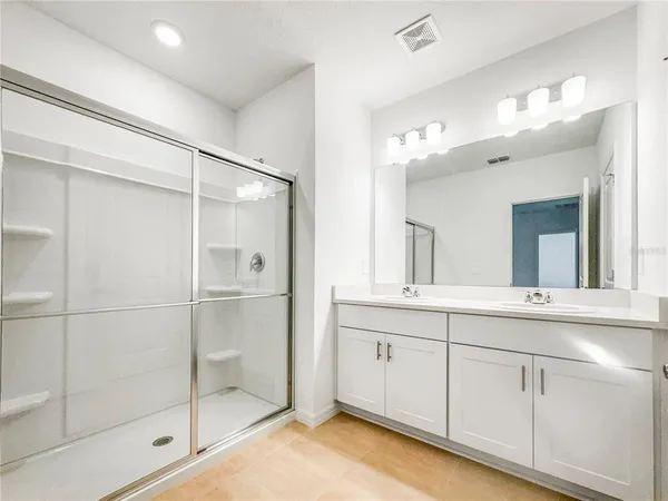 a bathroom with a shower sink and mirror