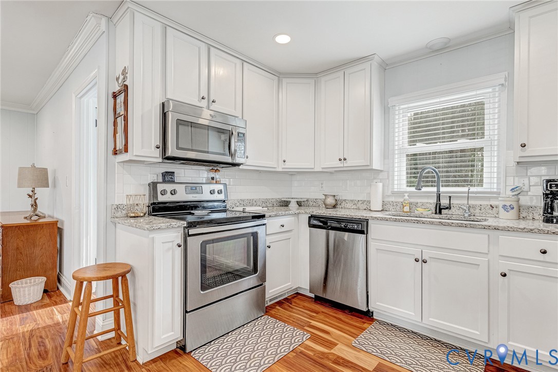 202 Bruce Road Tappahannock, VA 22560 - Photo 14 of 36 a kitchen with stainless steel appliances granite countertop a stove a sink and a microwave