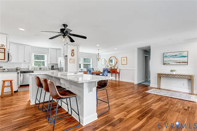 a kitchen with stainless steel appliances kitchen island granite countertop a table and chairs