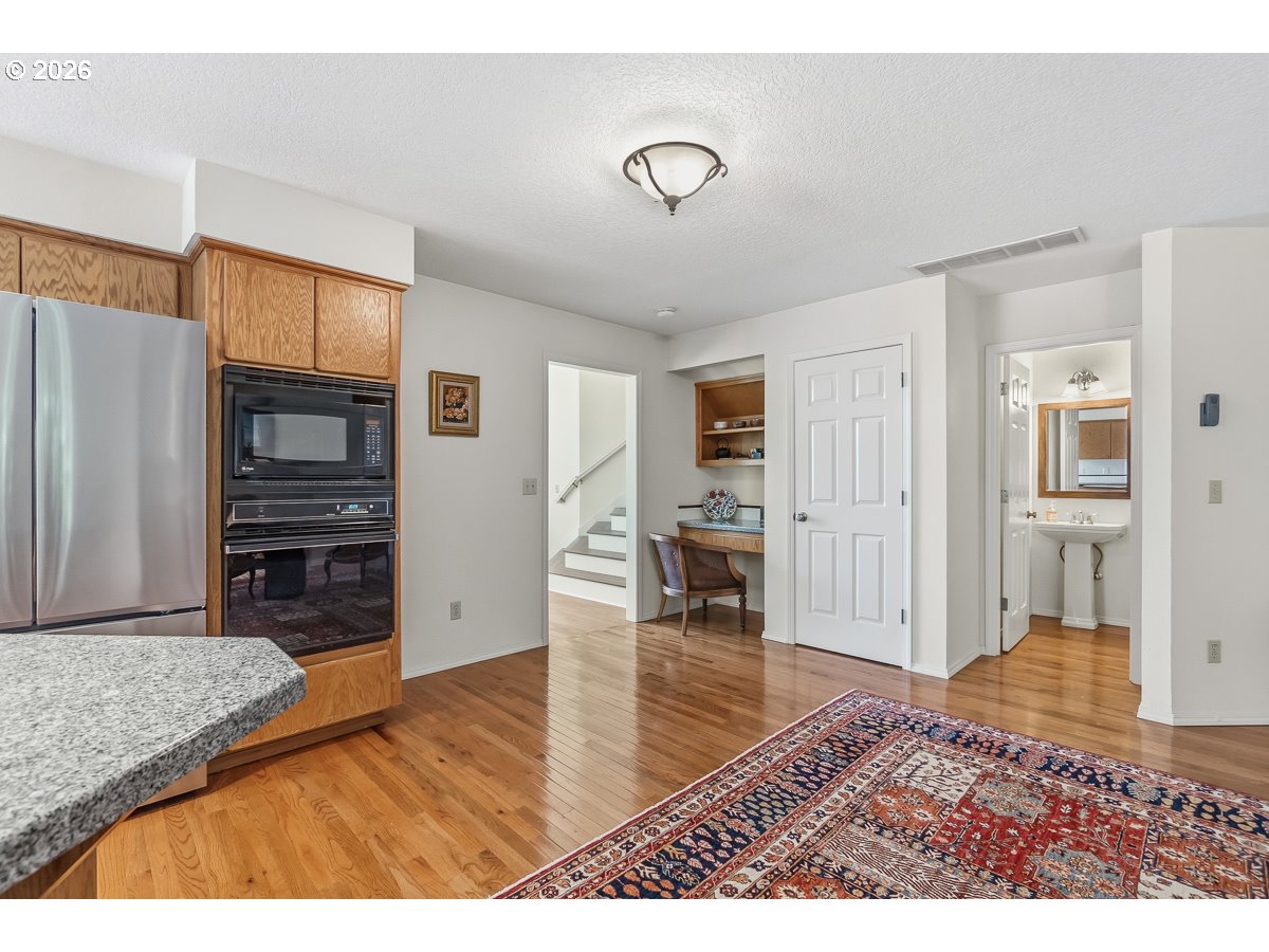 9675 Southwest 163rd Avenue Beaverton, OR 97007 - Photo 11 of 26 a open kitchen with cabinets and wooden floor