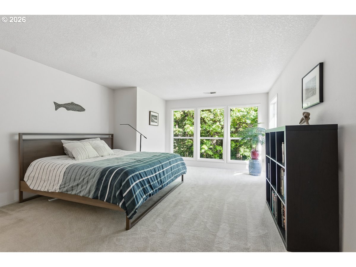 9675 Southwest 163rd Avenue Beaverton, OR 97007 - Photo 12 of 26 a spacious bedroom with a bed window and a dresser