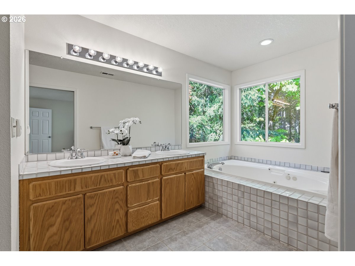 9675 Southwest 163rd Avenue Beaverton, OR 97007 - Photo 14 of 26 a bathroom with a tub a sink and mirror