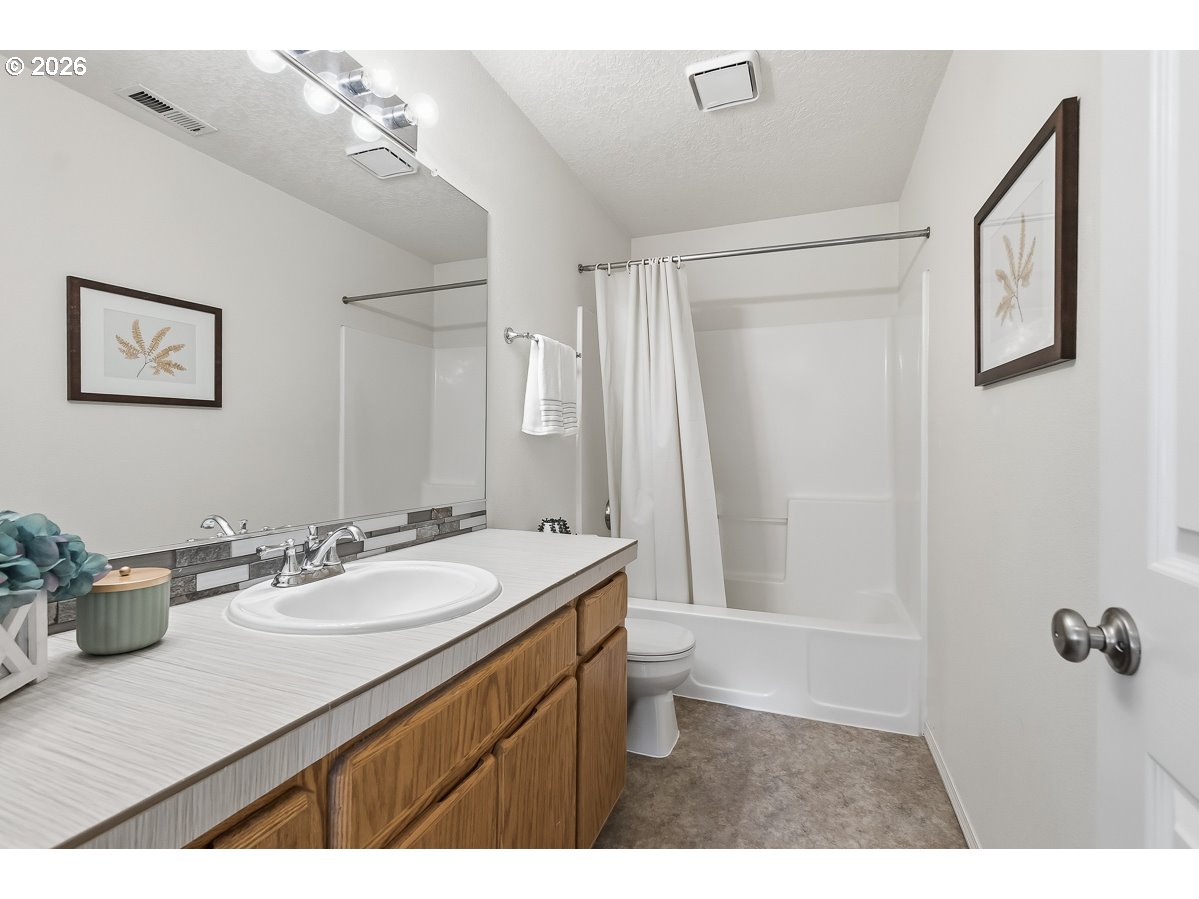 9675 Southwest 163rd Avenue Beaverton, OR 97007 - Photo 17 of 26 a bathroom with a sink a toilet and a mirror