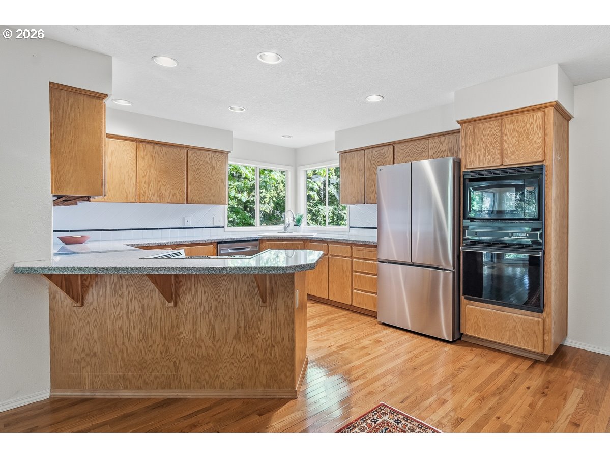 9675 Southwest 163rd Avenue Beaverton, OR 97007 - Photo 9 of 26 a kitchen with stainless steel appliances a refrigerator a sink a stove a microwave a counter top and oven
