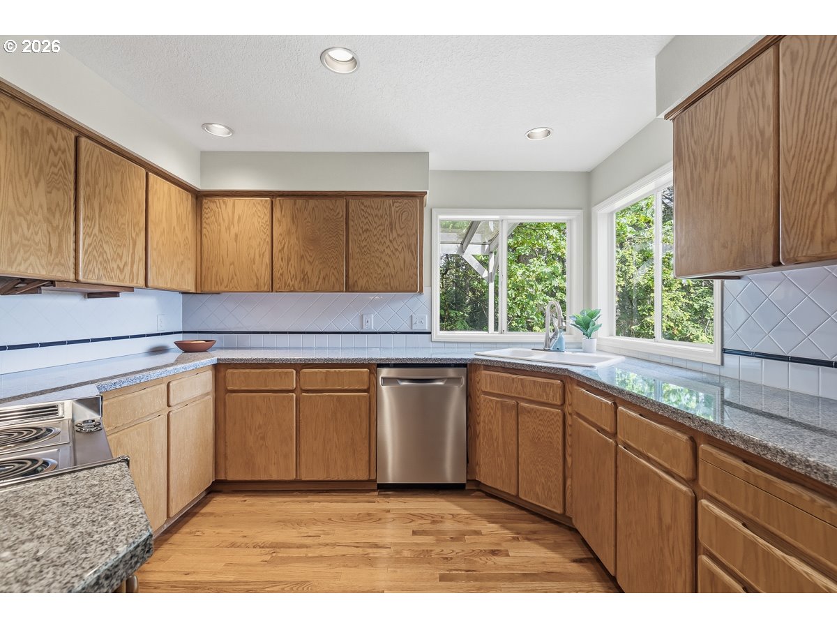 9675 Southwest 163rd Avenue Beaverton, OR 97007 - Photo 10 of 26 a kitchen with granite countertop a sink window and cabinets