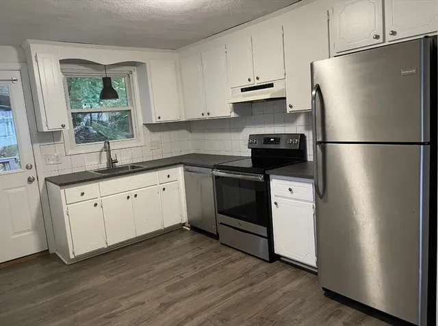 a kitchen with a refrigerator sink and cabinets