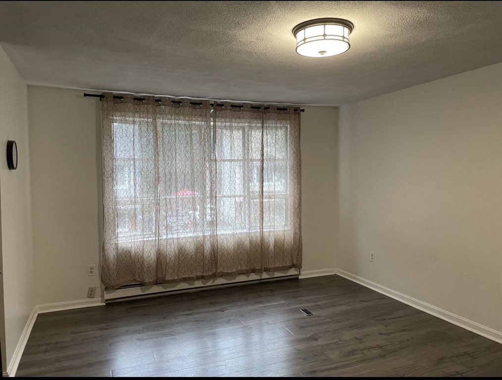 9 Grove Terrace, Unit 2 Boston, MA 02132 - Photo 4 of 8 an empty room with wooden floor and windows