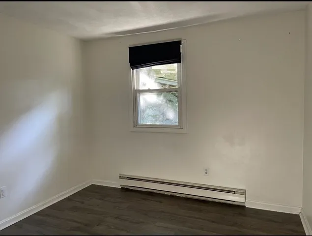 a view of a small space with wooden floor and a window