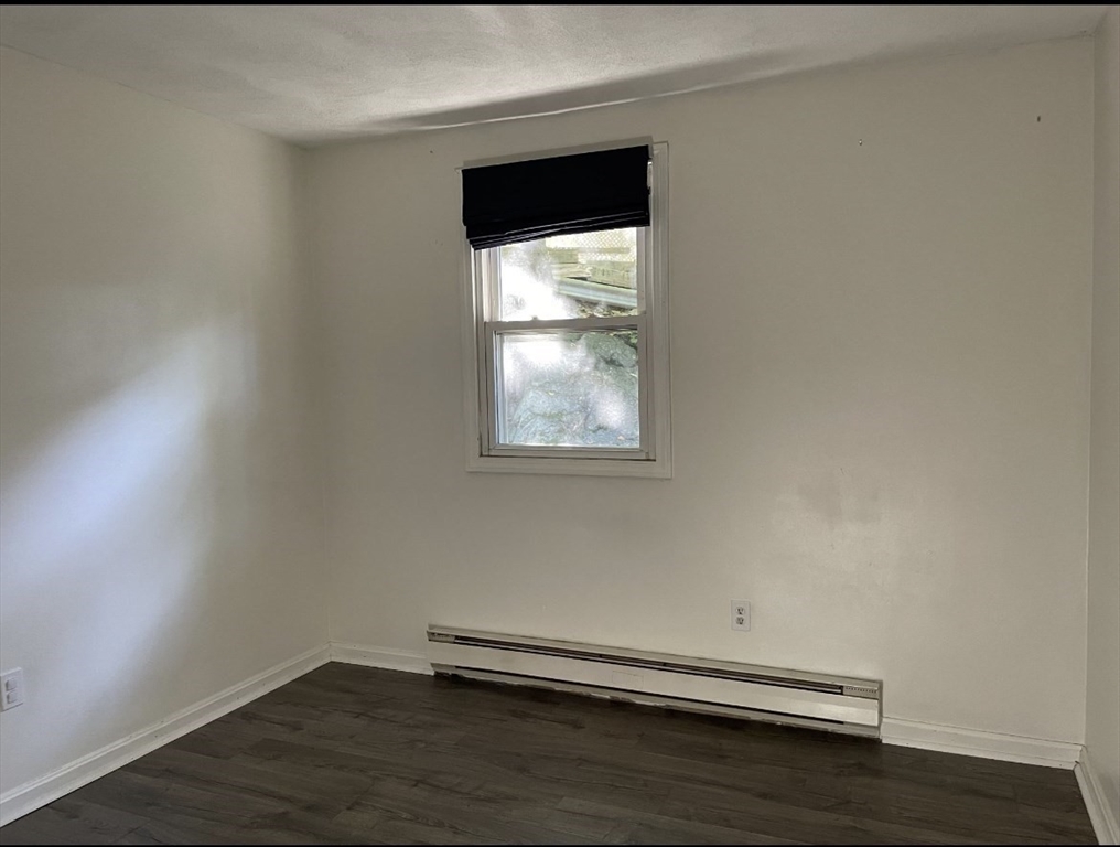 9 Grove Terrace, Unit 2 Boston, MA 02132 - Photo 5 of 8 a view of a small space with wooden floor and a window