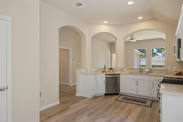 a kitchen with a sink cabinets and wooden floor