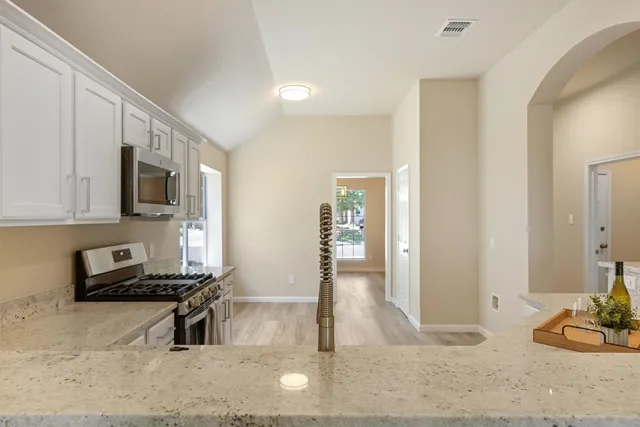 a living room with furniture a flat screen tv and kitchen view