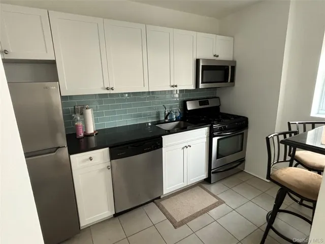 a kitchen with a sink and white cabinets
