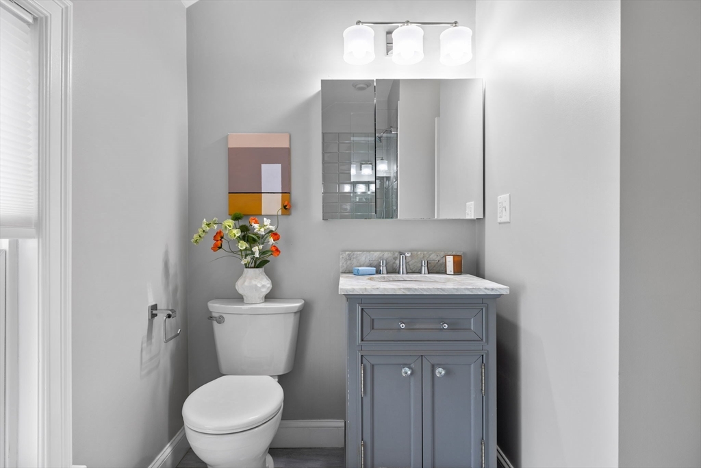 25 Clark Street, Unit 2 Somerville, MA 02143 - Photo 15 of 20 a bathroom with a granite countertop toilet a sink and mirror