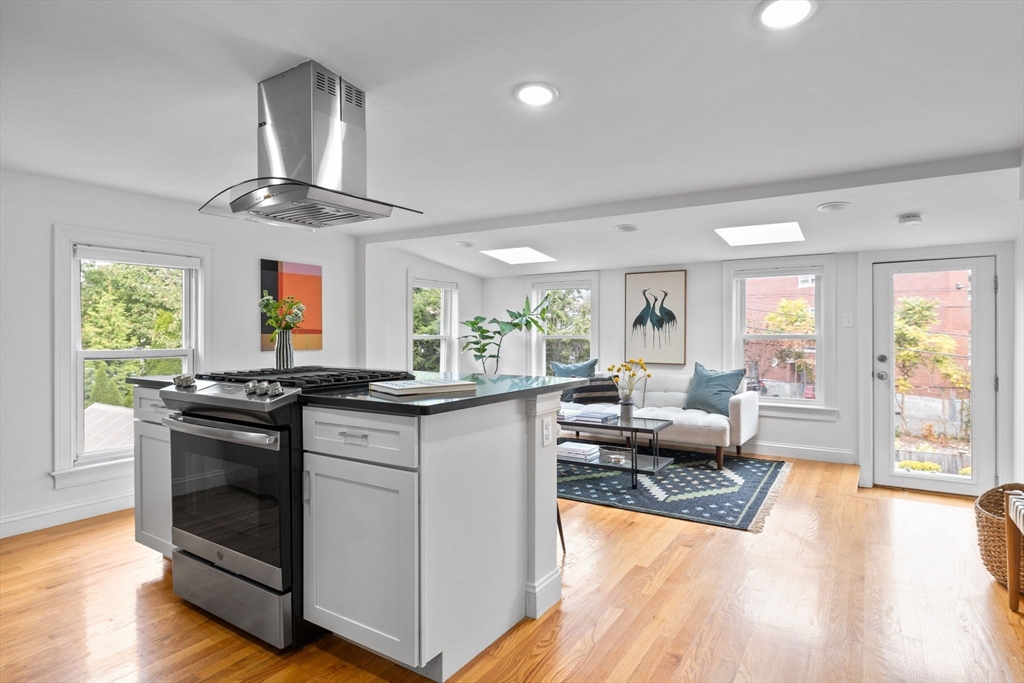25 Clark Street, Unit 2 Somerville, MA 02143 - Photo 6 of 20 a kitchen with stainless steel appliances granite countertop a stove and wooden floor