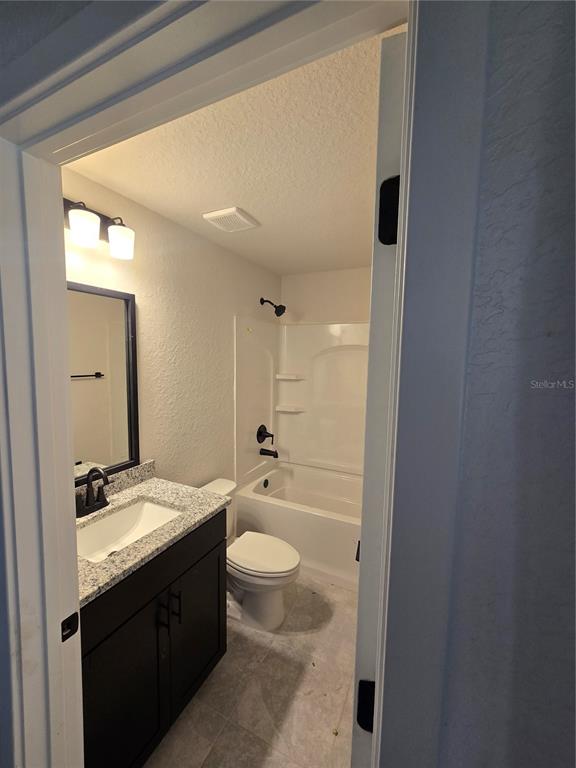 2605 Clearwood Street Inverness, FL 34452 - Photo 13 of 21 a bathroom with a granite countertop sink toilet a large mirror a bathtub and shower